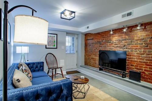 a living room with a blue couch and a brick fireplace at 2-BR Petworth Pad Walk to METRO Subway in Washington, D.C.