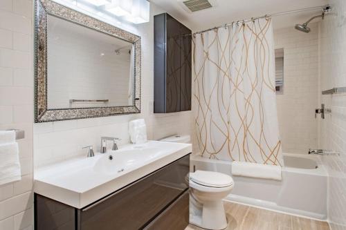 a bathroom with a sink and a toilet and a mirror at 2-BR Petworth Pad Walk to METRO Subway in Washington, D.C.