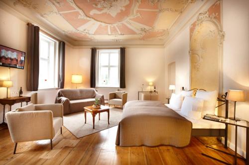 a bedroom with a bed and a living room at Hotel Pelli Hof Rendsburg by Tulip Inn in Rendsburg