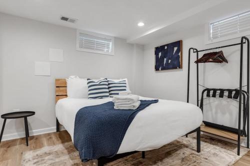 ein weißes Schlafzimmer mit einem Bett mit blauen und weißen Kissen in der Unterkunft ALX Home Away from Home in Alexandria