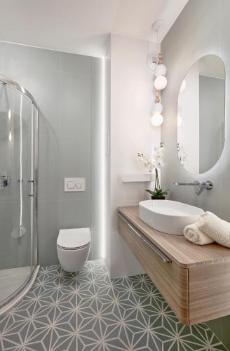 a bathroom with a tub and a toilet and a mirror at Premium City Apartments in Bydgoszcz
