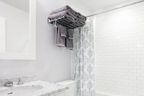 a bathroom with a sink and a shower with towels at Historic Charming Home in Old Town in Alexandria