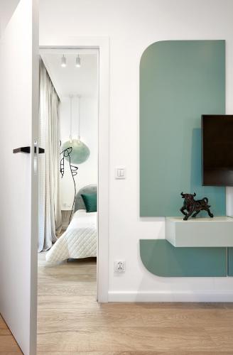 a living room with a tv and a bedroom at Premium City Apartments in Bydgoszcz