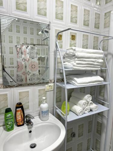 a bathroom with a sink and a mirror and towels at Sol Apartment - 2 Bedrooms in Shkodër