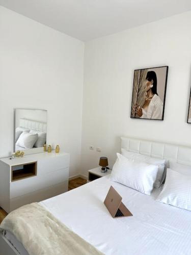 a bedroom with a white bed with a laptop on it at Sol Apartment - 2 Bedrooms in Shkodër