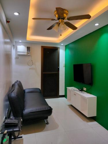 ein Wohnzimmer mit einem Stuhl und einer grünen Wand in der Unterkunft Jds Place in Pasig