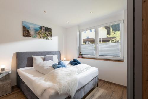 una camera da letto con un grande letto bianco con una grande finestra di Haus Alpenlieb a Wörgl