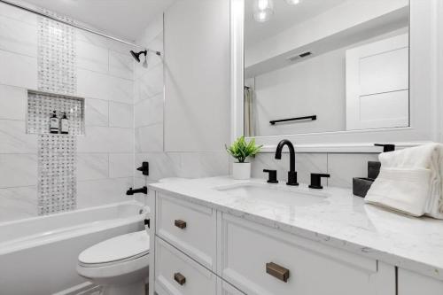 Baño blanco con aseo y lavamanos en Excellent 2-BR Condo in Hip Area of DC, en Washington