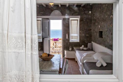 a living room with a couch and a view of the ocean at Artemis Apartments in Tinos