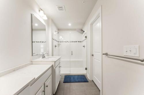 uma casa de banho branca com 2 lavatórios e um chuveiro em Ashburn 4-BR Homestay Close to Dulles & METRO em Brambleton
