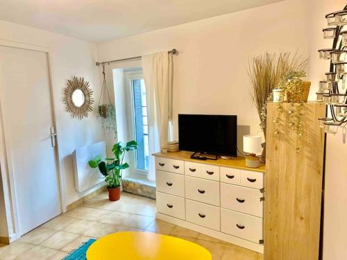 - un salon avec une télévision au-dessus d'une commode dans l'établissement Studio Centre historique Carpentras : Mya lee, à Carpentras