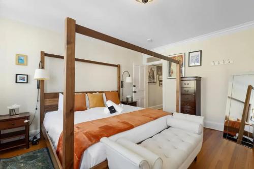 - une chambre avec un grand lit et un canapé blanc dans l'établissement Quintessential Georgetown Homestay Wisconsin Ave, à Washington