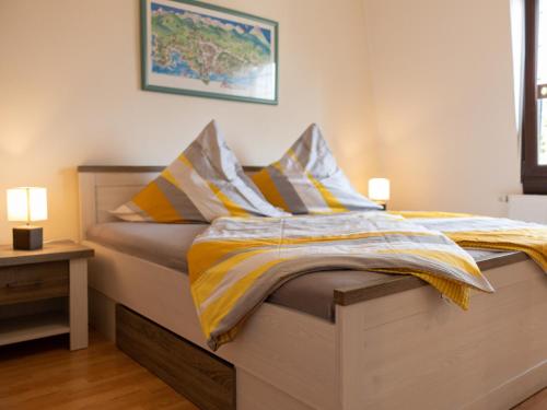 Schlafzimmer mit einem Bett mit gelber und weißer Bettwäsche in der Unterkunft Ferienwohnung Severin in Bottrop