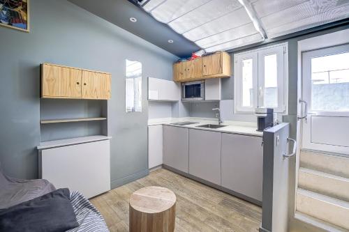 d'une cuisine avec des placards blancs, un réfrigérateur et une fenêtre. dans l'établissement Maison Bianchi - Jean Médecin, à Nice