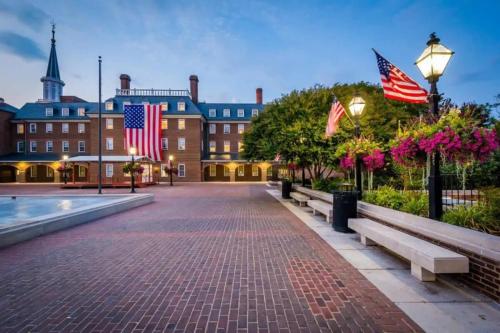 a brick walkway in front of a building with american flags at LUXE Cameron House Off King St Est 1870 in Alexandria