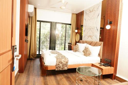 a bedroom with a bed and a glass table at Hotel Padma Krishna in Pune