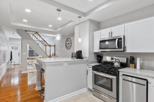 a kitchen with white cabinets and a stove top oven at Charm City Homestay in Washington Village in Baltimore