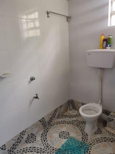 La salle de bains est pourvue de toilettes et de carrelage. dans l'établissement Cassie Homes Eldoret 1bedroom, à Eldoret