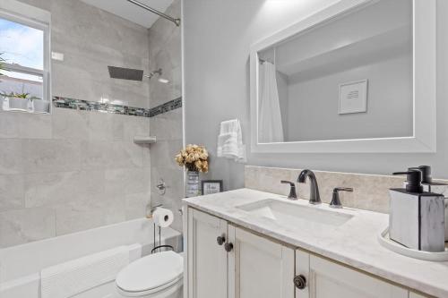 a bathroom with a sink and a toilet and a mirror at Short Drive to Capitol Hill-Convenient MD Homestay in Capitol Heights