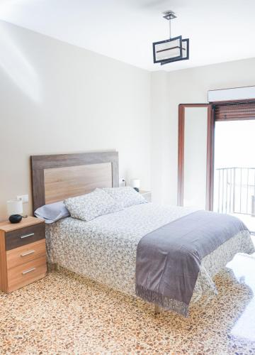 Un dormitorio con una cama y una cómoda y una ventana. en Casa de los Abuelos, en Úbeda