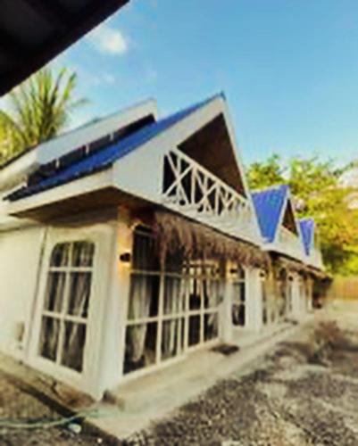 a large white building with a blue roof at Hayya Hayya Villas in Ocoy