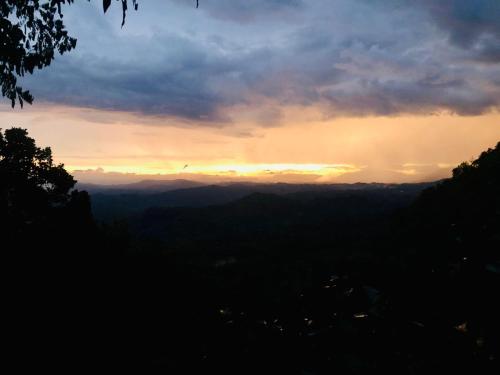 a sunset in the mountains with the sun setting at Ithin Kithul Villa in Beragala