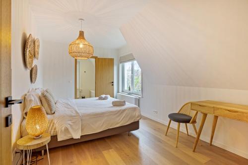 Schlafzimmer mit einem Bett, einem Tisch und Stühlen in der Unterkunft Maison Malo in De Haan