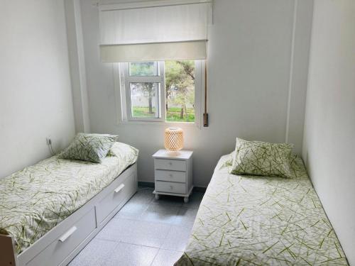 a bedroom with two beds and a window at Holiday Home La Atalaya de Conil in Conil de la Frontera