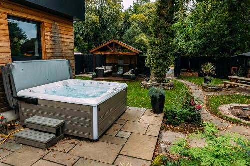 a hot tub in the backyard of a house at Stylish Loch Lomond lodge in stunning surroundings in Balloch