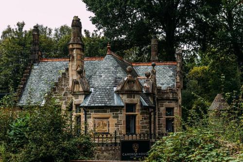 an old house with a chimney on top of it at Stylish Loch Lomond lodge in stunning surroundings in Balloch
