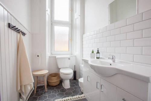 a white bathroom with a toilet and a sink at Stunning 2 bed property in heart of West End in Glasgow