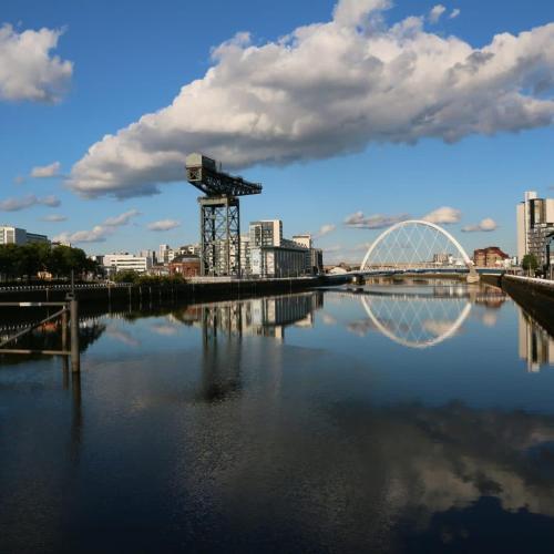 a bridge over a river with a city in the background at Glasgow Green Getaway with Free Parking in Glasgow