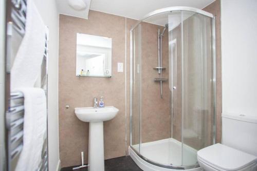 a bathroom with a shower and a sink and a toilet at Beautiful Flat with Panoramic Views over the City in Glasgow
