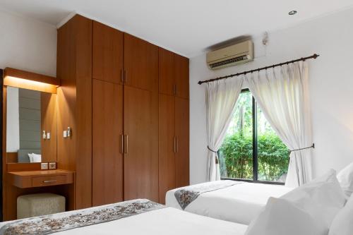 a bedroom with two beds and a window at LA CASA BORNEO in Bentakan Kecil