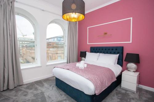 Un dormitorio rosa con una cama con un osito de peluche. en Stunning One bed with parking in City Centre en Glasgow