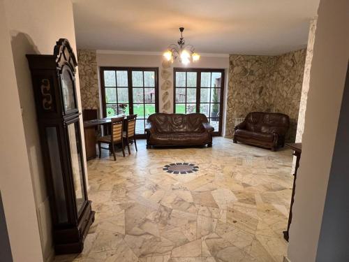 a living room with couches and a table and chairs at Willa Na Krańcu Kazimierza in Uściąż