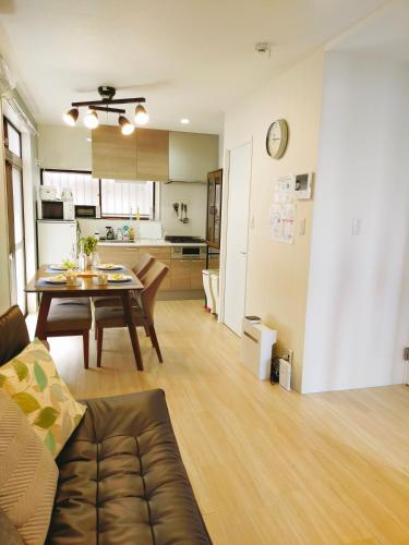 a living room with a table and a kitchen at 15min to Haneda Airport - Homies House Kamata for up to 9 guests in Tokyo