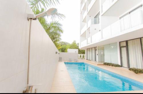 a swimming pool in front of a building at The Pine Court in Accra