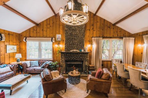 a living room filled with furniture and a fireplace at Heritage Log Cabin and Garden w Outdoor Hot Tub in Medlow Bath