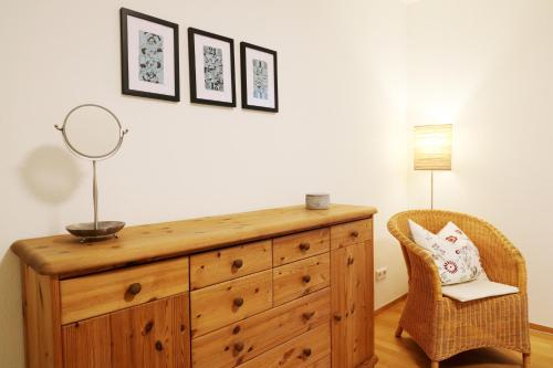 a wooden dresser with a mirror and a chair at Ferienwohnung "Dorfliebe" mit privater Sauna und 4 Schlafzimmern in Breitnau in Breitnau