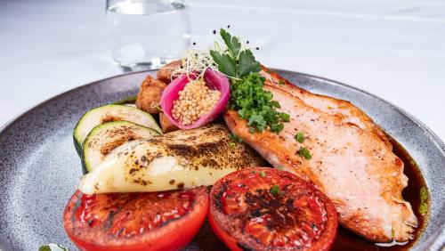 a plate of food with meat and vegetables on a table at Rosengarten Hotel & Restaurant in Sopron