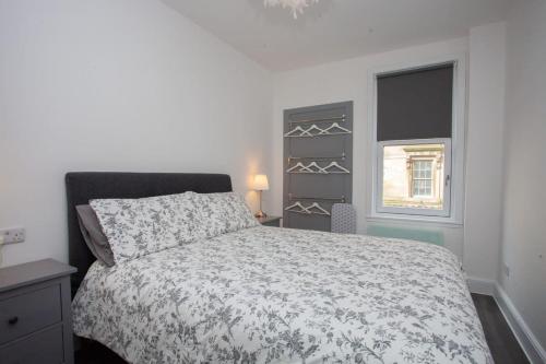 a bedroom with a bed and a window at Newly Renovated City Apartment in Glasgow