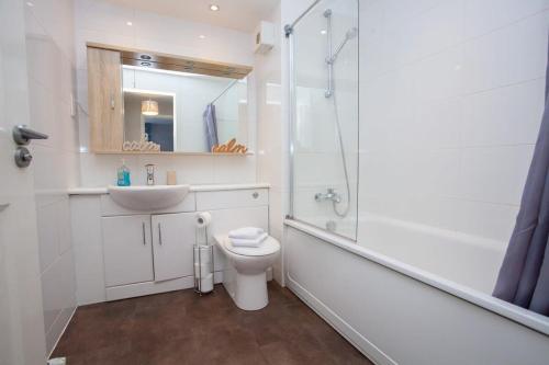 a bathroom with a sink and a toilet and a shower at Stunning 3 Bed Apartment in Bearsden