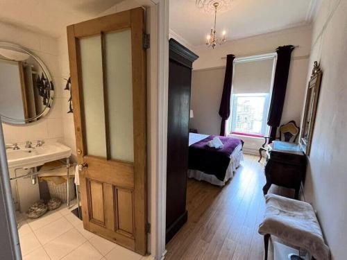 a bathroom with a bedroom with a bed and a sink at Stunning West End 3 Bed in Glasgow