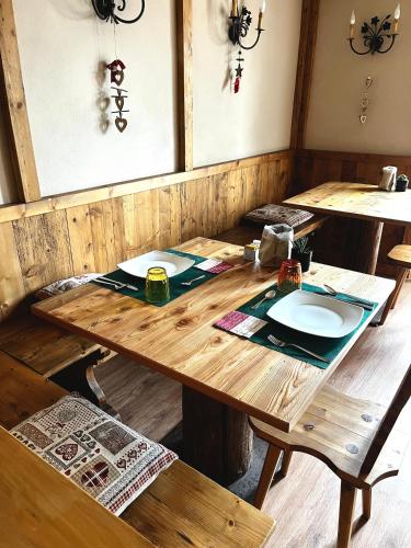 Una mesa de madera con dos platos encima. en Hotel Riva Sport & Wellness, en Vione