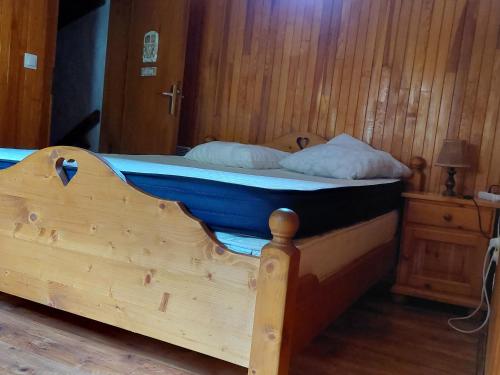 a wooden bed with two pillows on top of it at CHALETS impasse CHARMAURY et refuge SAMOENS in Samoëns