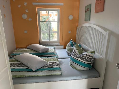 a room with three beds with pillows and a window at Smart Home - Die etwas andere Ferienwohnung! in Brandenburg an der Havel