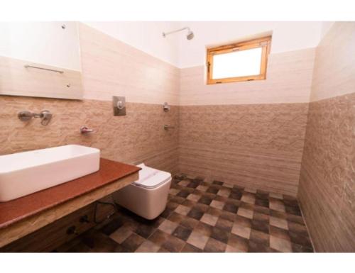 y baño con lavabo y aseo. en Kartok resort, Leh, en She