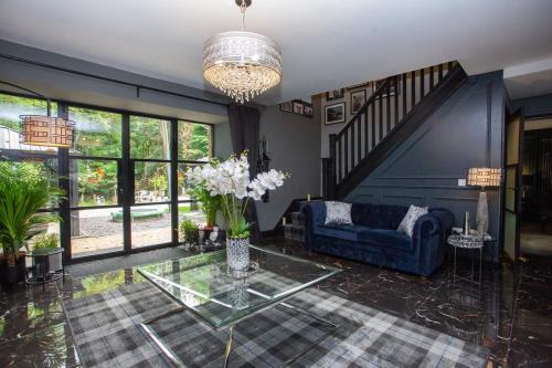 a living room with a blue couch and a glass table at The Ultimate Luss Retreat in Luss