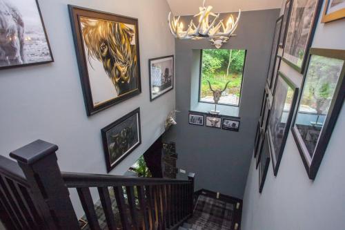 a staircase with pictures on the walls and a chandelier at The Ultimate Luss Retreat in Luss